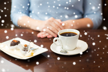 close up of woman hands with coffee and dessert