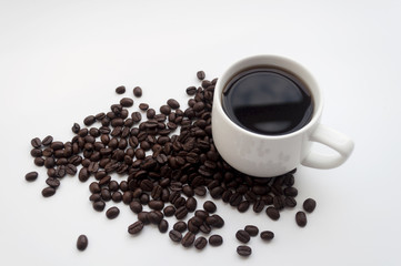 isolated white cup of coffee and coffee beans on white backgroun