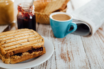 Homemade peanut butter and jelly sandwich on wooden background