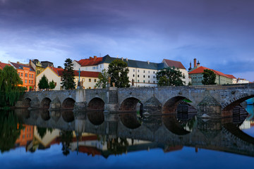 Gothic medieval stony bridge on Otava river. Oldest bridge historical town Pisek, South Bohemia, Czech republic, Europe. Beautiful evening twilight in the town with beautiful bridge in Pisek.