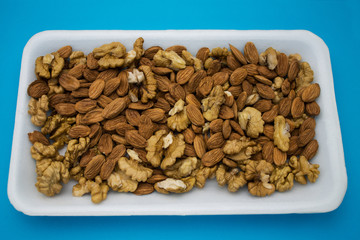 apricot stones and walnuts in blue background