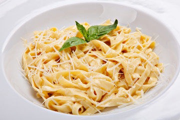 Close-up italian pasta plate with grated parmesan cheese and bas