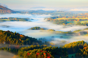 Czech typical autumn landscape. Hills and villages with foggy morning. Morning fall valley of Bohemian Switzerland park. Hills with fog, landscape of Czech Republic, Ceske Svycarsko, wild Europe.