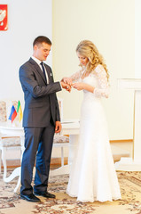Невеста надевает обручальное кольцо на палец жениха....