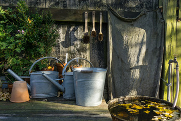 romantic idyllic plant table in the garden with old retro flower pot pots, tools and plants