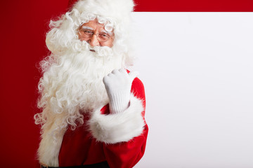 Photo of happy Santa Claus in eyeglasses looking at camera .