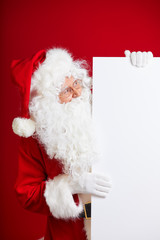 Photo of happy Santa Claus in eyeglasses looking at camera .