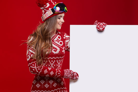 Happy Woman In Winter Outerwear Over White Banner In Hands At St