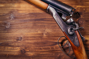 Shotgun on wooden background - obrazy, fototapety, plakaty