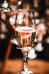 Sparkling champagne in glass with raspberry