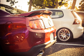 Sun shines over red Ford Mustang - obrazy, fototapety, plakaty