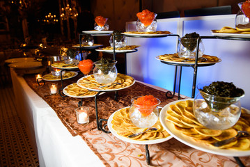 Plates with puncakes and caviare