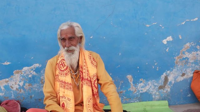 Hindu sadhu, holy man,  sitting and talking to people off camera in Pushkar, Rajasthan