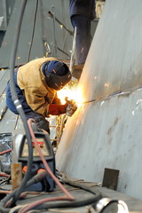 welder with protective mask welding metal
