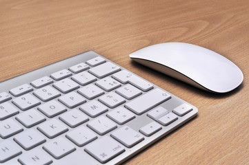 Keyboard and mouse on a wooden background, close-up