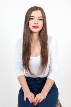 Beautiful Young Woman with Fresh Clean Skin touch own face. Red lips, red lipstick. Cosmetology, beauty and spa. 