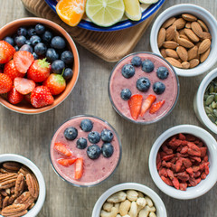 Coconut milk chia pudding with berry smoothie with berries on top, served with fruits and nuts, selective focus, top view, square