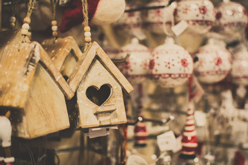 Hanging Christmas decoration in the shop with tags, with blurred baubles on the back, selective focus