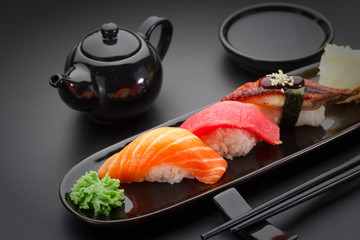 Tuna, salmon and eel sushi nigiri on the black table