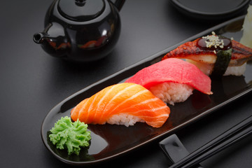 Tuna, salmon and eel sushi nigiri on the black table