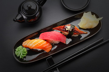 Tuna, salmon and eel sushi nigiri on the black table