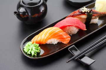 Tuna, salmon and eel sushi nigiri on the black table