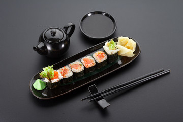 Salmon hoso maki on a black plate