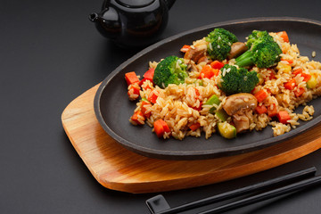 Japanese cuisine. Rice with vegetables over black background