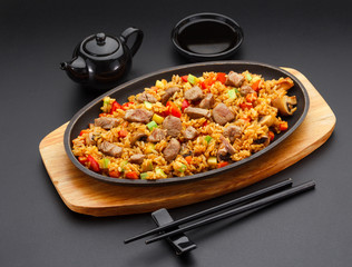 Japanese cuisine. Rice with pork over black background.