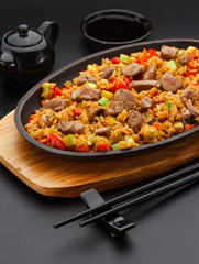 Japanese cuisine. Rice with pork over black background.