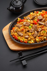 Japanese cuisine. Rice with pork over black background.