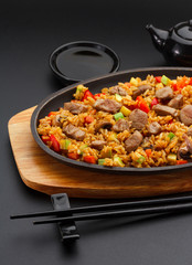 Japanese cuisine. Rice with pork over black background.