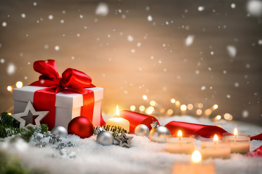 Weihnachten Hintergrund mit Geschenk und rotem Band, Kerzen, Lichterkette, Weihnachtsdeko und Schnee