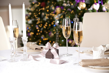 Christmas gifts on the beautiful table with Christmas tree on ba