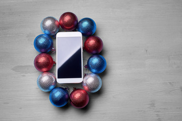 The wooden table with a phone and Christmas decorations.