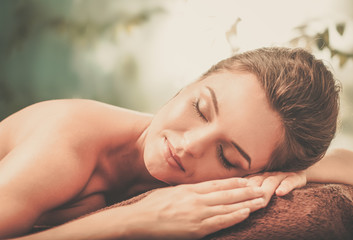 Obraz na płótnie Canvas Beautiful young woman having massage in a spa salon