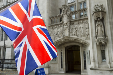 Fototapeta na wymiar British Union Jack flag flying in front of The Supreme Court of the United Kingdom in the public Middlesex Guildhall building in Parliament Square in London