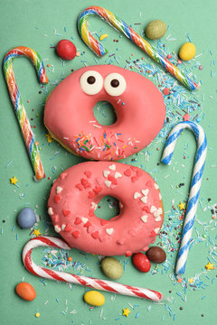 Funny glazed donuts on green background