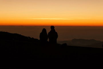 Silhouette couple lovers watching sunrise