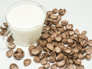 Chocolate breakfast cereal and a cap of milk.