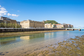 Obraz premium View over the river Urumea to the Victoria Eugenia Theater, a neoplateresque building, a special Spanish architecture, in Donostia San Sebastian. The river is passing through the very nice Basque city