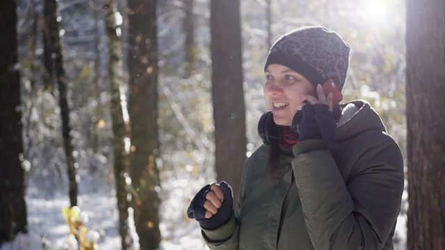 young girl talking on the phone in the winter forest