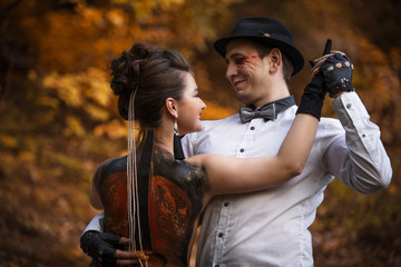 Young smiling man imitating music performance on woman's back with painted violin.