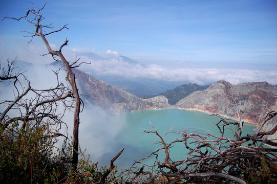 Acid lake in crater of activ voulcan Ijen with  smoke of sulfur