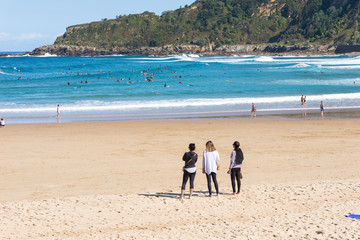 Surfer do water sport, people relax at the beach La Zurriola in Donostia San Sebastian. The beach...