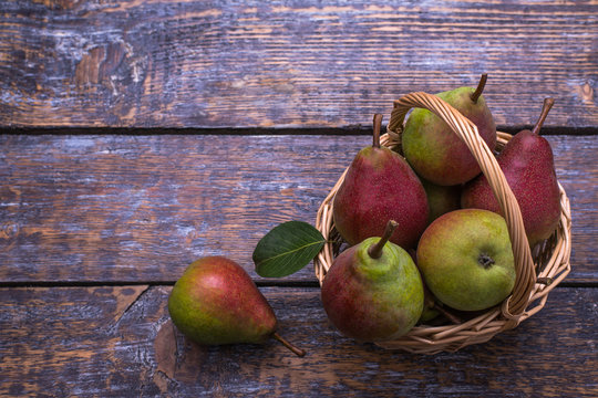Pears in a basket on a wooden background. Selective focus