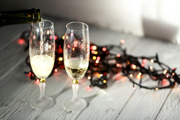 Two glasses of champagne and garland on a white floor