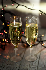 Two glasses of champagne and garland on a white floor