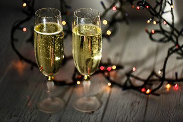 Two glasses of champagne and garland on a white floor