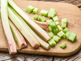 Edible rhubarb stalks on the wooden table.